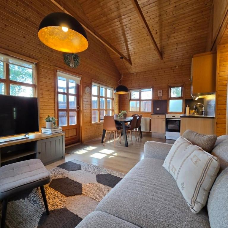 a living room with a couch and a kitchen at Akureyri Cottages in Akureyri
