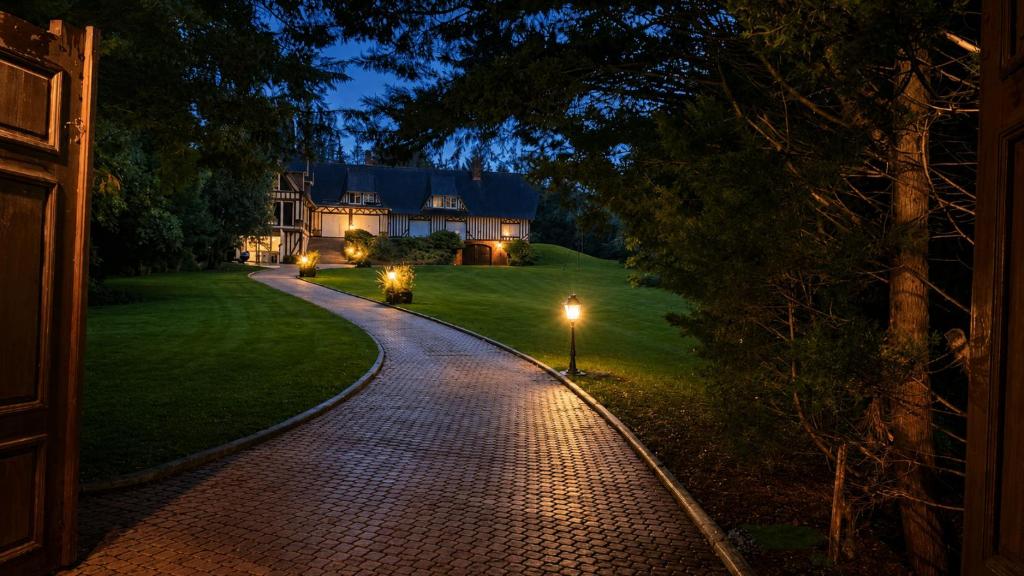 a brick driveway leading to a house at night at Le Jardin de Villevaudé, proche Disney & Paris in Villevaudé
