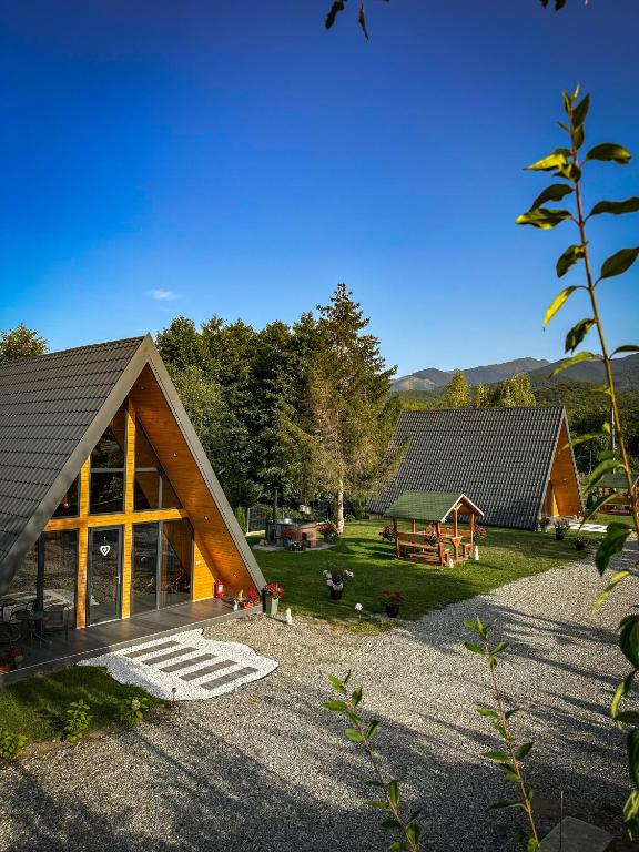 a large wooden cabin with a yard with trees at Povestea din Munti in Arpaşu de Sus