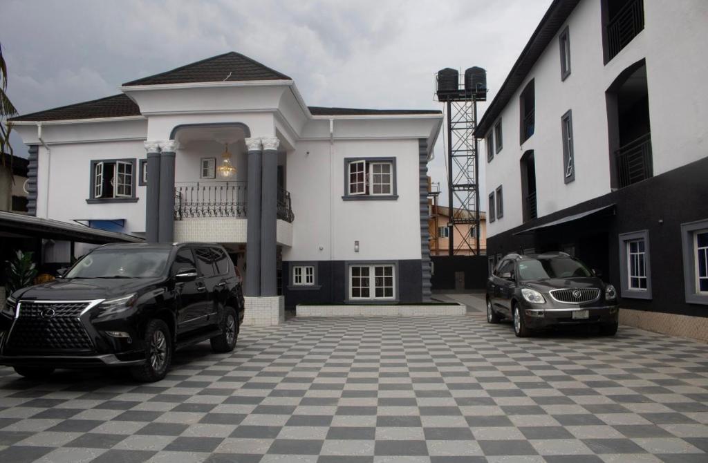 two cars parked in a parking lot in front of a house at Star Haven Hotel and suites in Badore