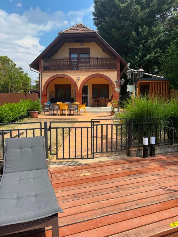 a house with a wooden deck with a fence at Csuka48 Apartman in Szarvas