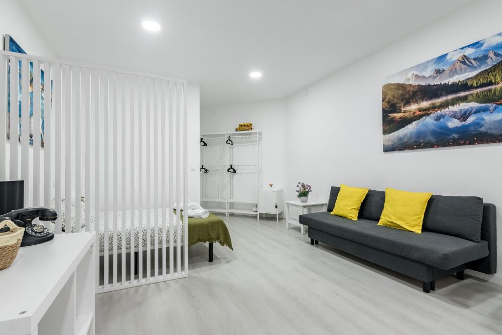 a living room with a blue couch and yellow pillows at Studio New Complete 4 pax in Madrid
