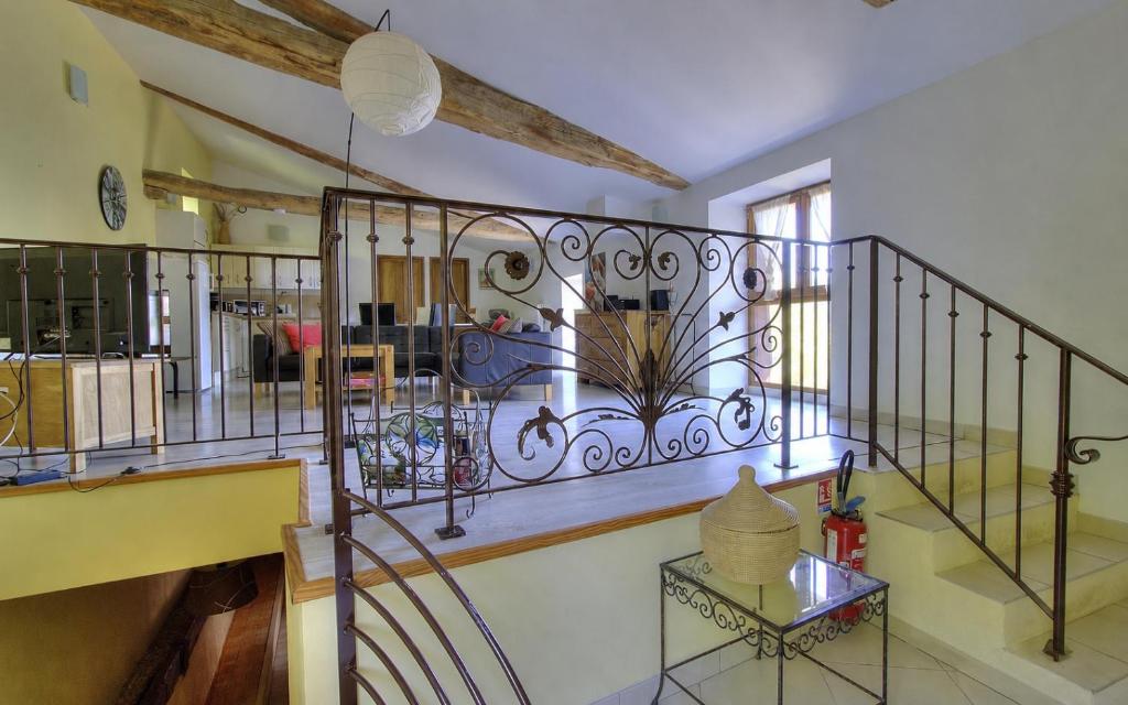 a room with a staircase with a wrought iron railing at La Bégude D'Amalthée in Vernay