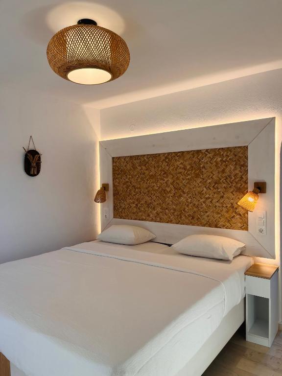 a bedroom with a large white bed and a wall at Fotinos House Skiathos in Skiathos