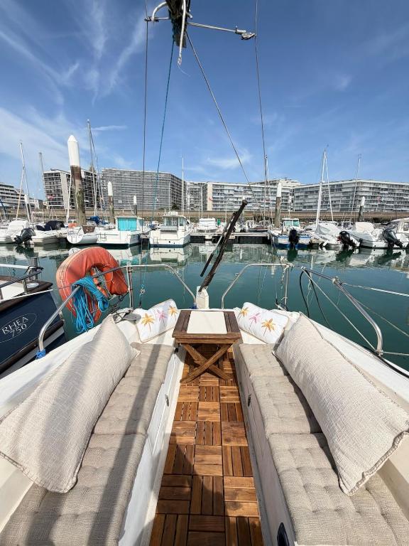 a boat with two pillows and a table on the deck at Nuit insolite voilier in Le Havre