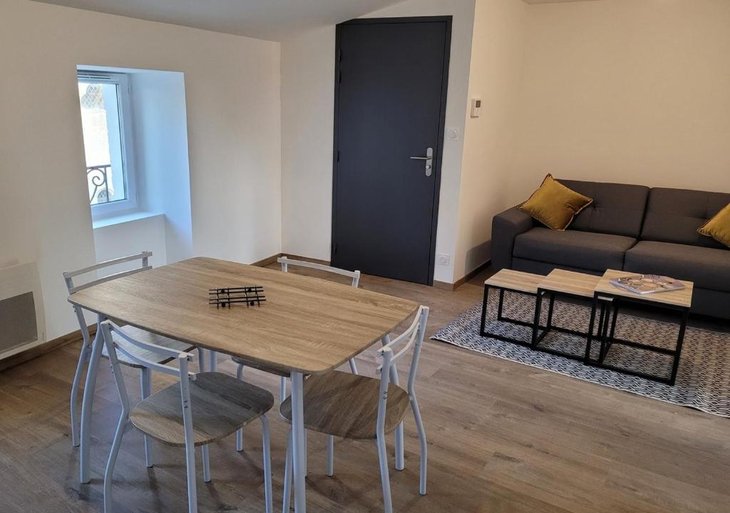 a living room with a table and chairs and a couch at Le Logis du Donjon 2 in Les Herbiers