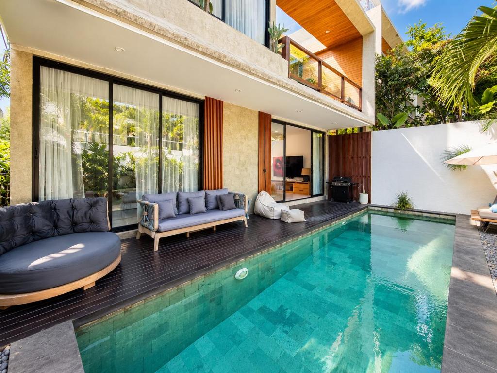 a house with a swimming pool and a villa at Village Berawa in Badung