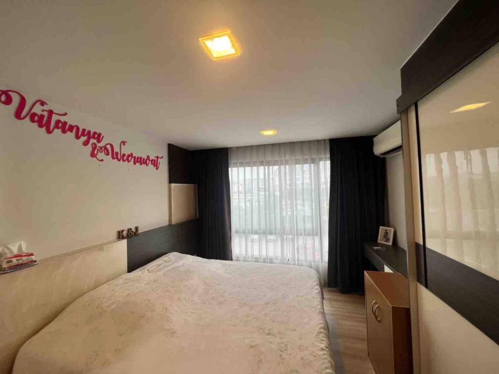 a bedroom with a bed and a sign on the wall at Living avenue condominuim in Ban Rong Khoei