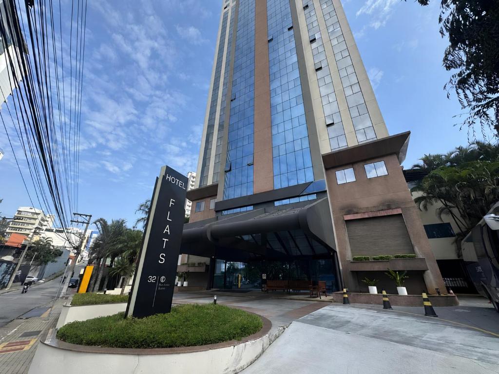 a tall building with a sign in front of it at Flat Executivo em Guarulhos - 6 in Guarulhos