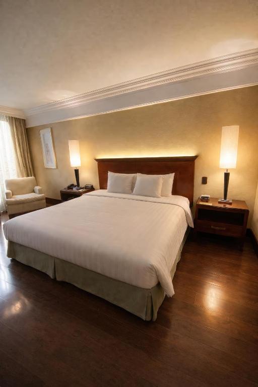 a large bed in a hotel room with two lamps at Regal Pacific Puerto Madero in Buenos Aires