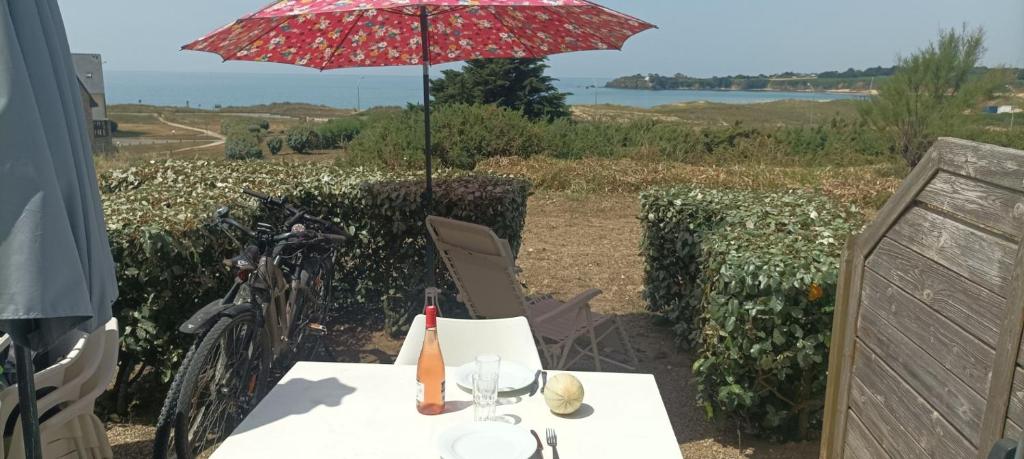 a table with an umbrella and a table with a table sidx sidx at Sud Ocean M N105 2P5 in Guidel