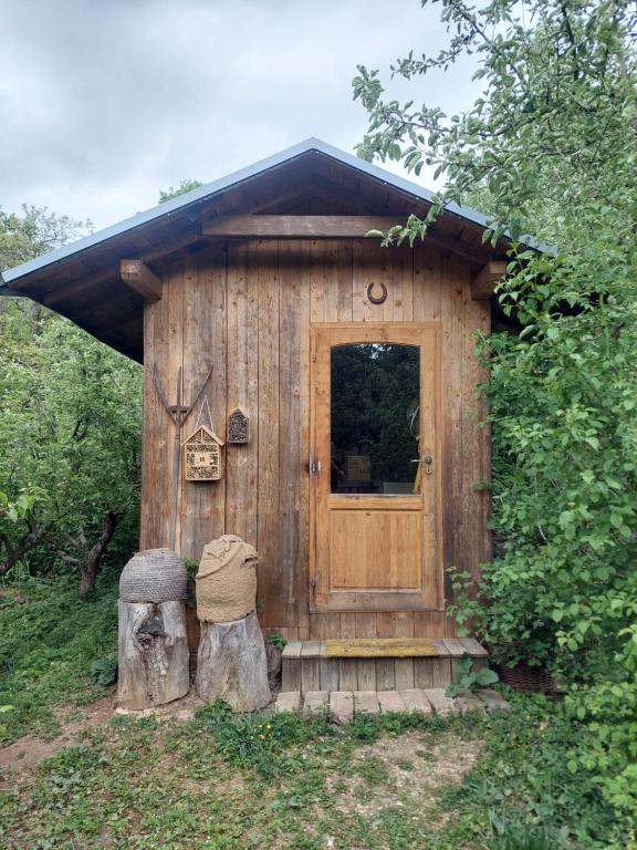 a small wooden house with a door and two logs at Api terapia Bojnice in Bojnice