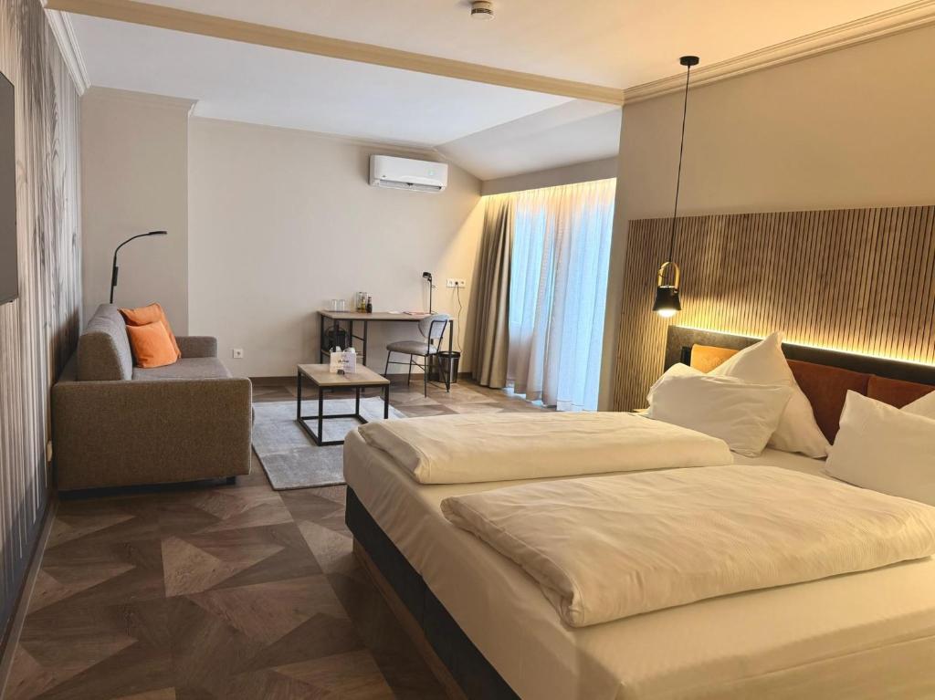 ein Hotelzimmer mit einem Bett und einem Stuhl in der Unterkunft Olymp Munich in Eching