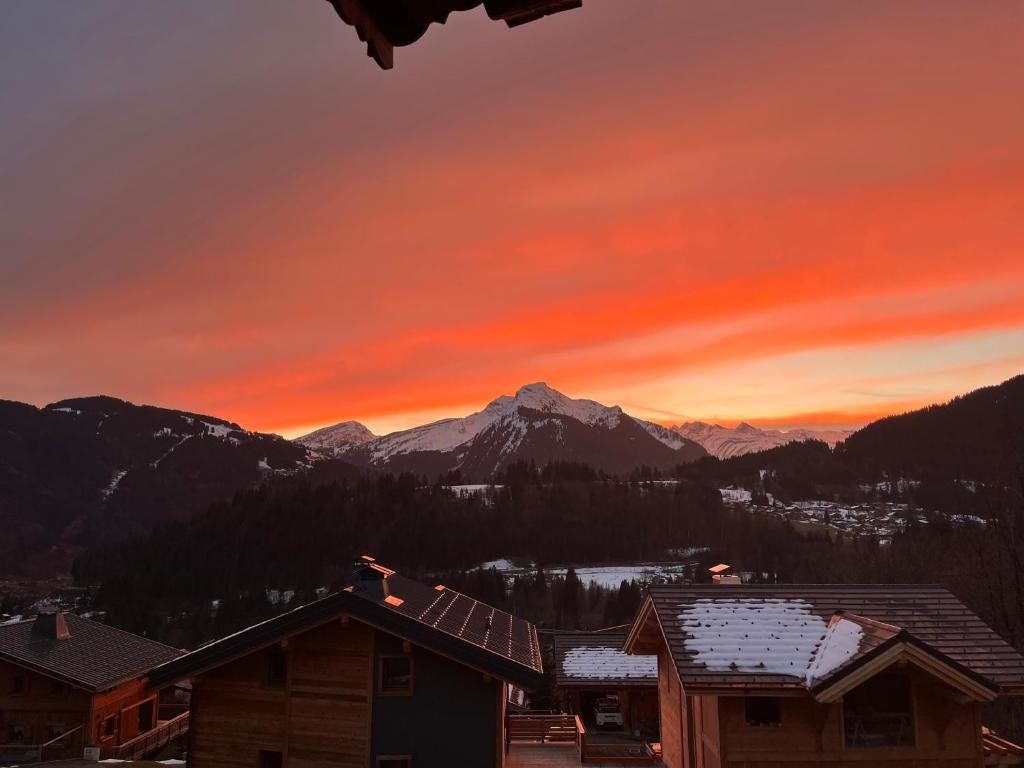 a sunset over the mountains with houses and snow at Chalet Mary in La Côte dʼArbroz