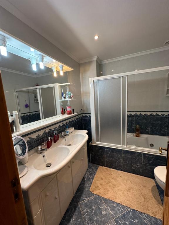 a bathroom with a sink and a shower and a toilet at Quarto em Bragança in Bragança