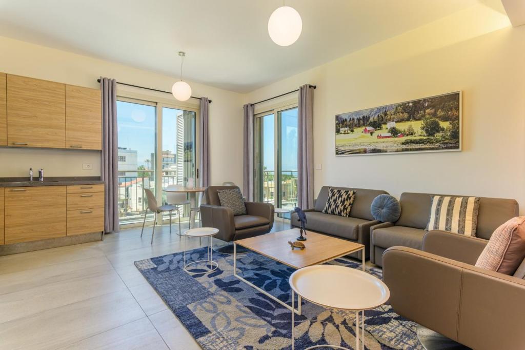 ein Wohnzimmer mit Sofa und Tisch in der Unterkunft Papiro Apart Hotel in Byblos