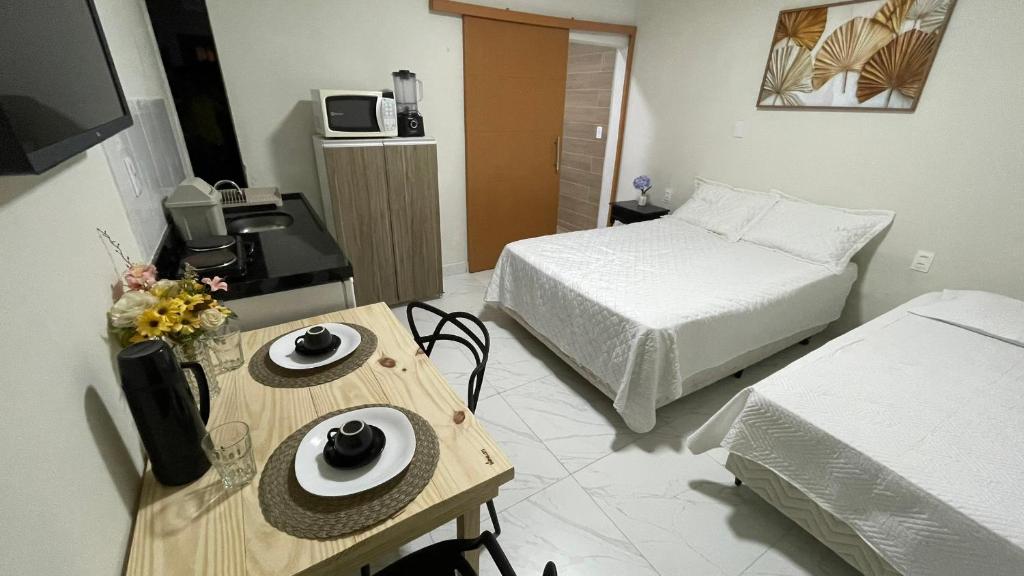 a small room with a bed and a table with plates on it at Flat em NATAL- RN in Natal