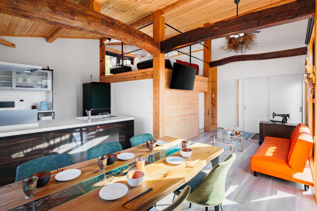 a dining room with a long wooden table and chairs at New Field Chalet 白馬 in Hakuba