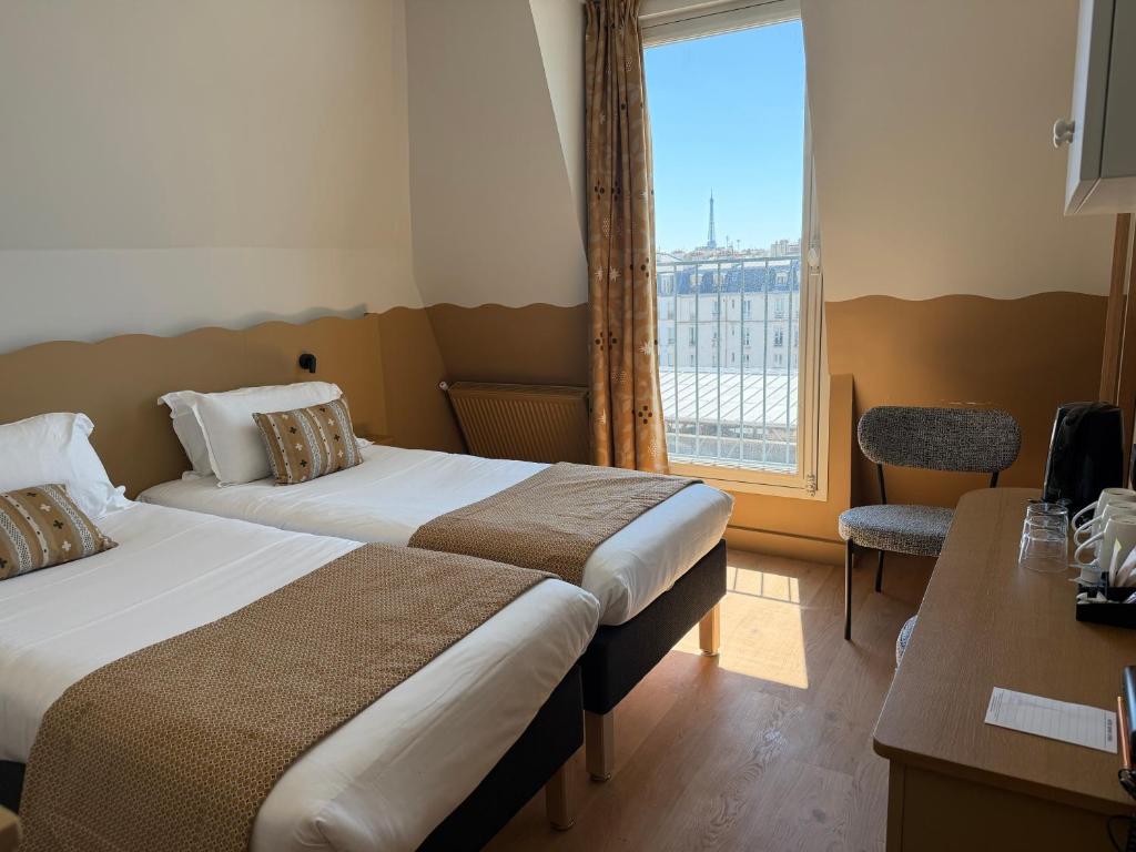 a hotel room with two beds and a window at Hotel Berne Opera in Paris