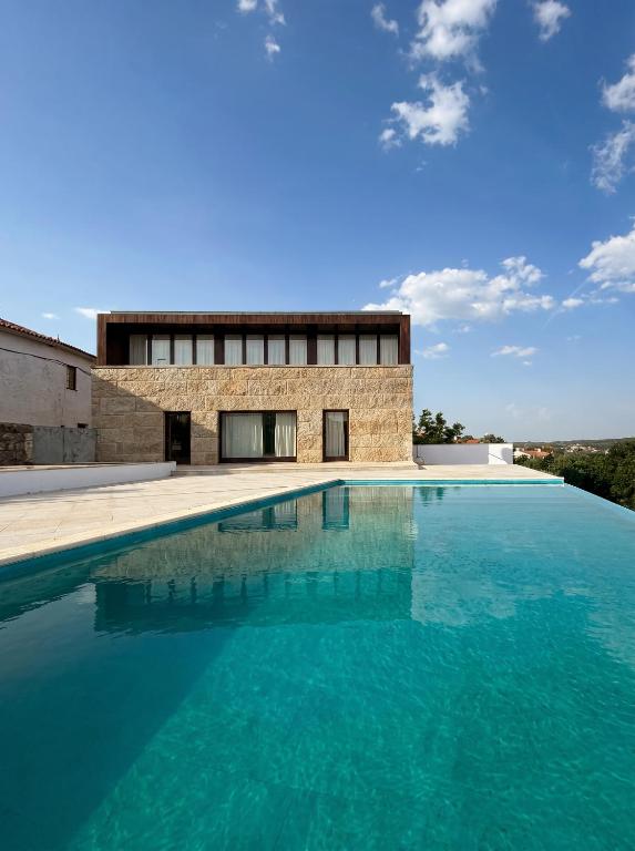 a swimming pool in front of a building at Seven Books House in Carrazeda de Anciães