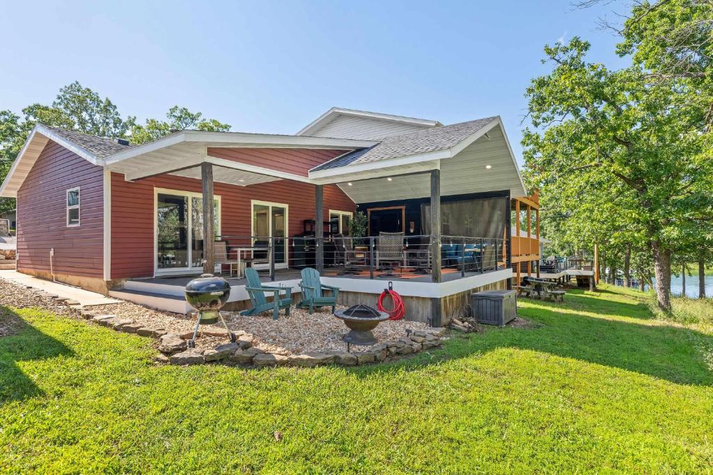 a tiny house with a patio and a yard at Red House - Lake Views - Outdoor Pool in Kimberling City