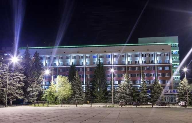 ein großes Gebäude in der Nacht mit Bäumen davor in der Unterkunft Zvezda Zhiguley Hotel in Toljatti