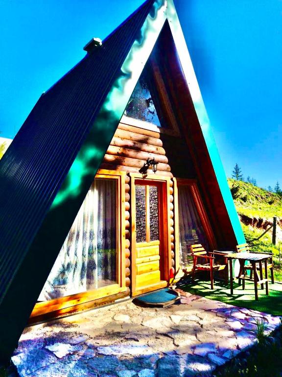a small log cabin with a table in front of it at M&K chalets in Žabljak