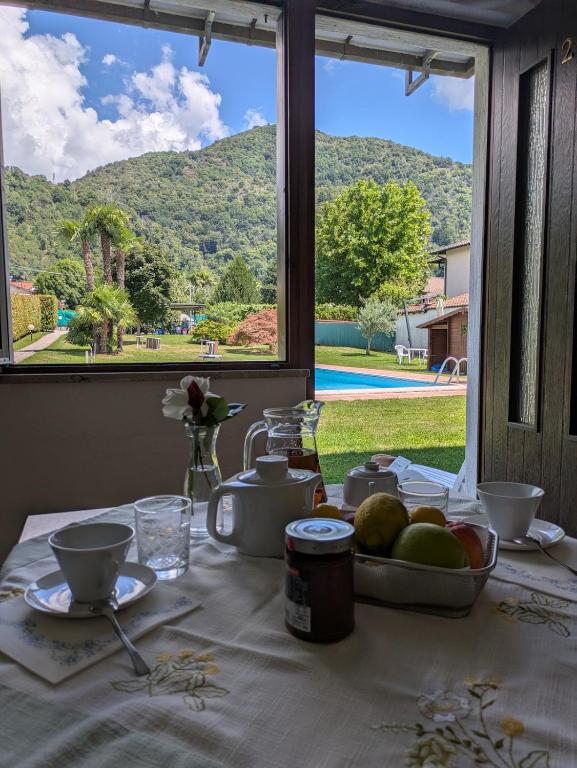 a table with a plate of fruit on a table with a window at Casa Augusta in Maccagno Superiore