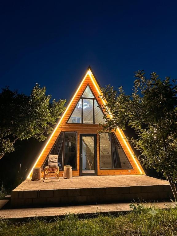 a house with a triangular roof with a chair in front at A-Frame House Tosor in Tossor