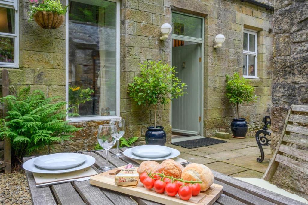 a table with plates of food on it in front of a house at 2 Bed in Hexham oc-88032 in Bardon Mill