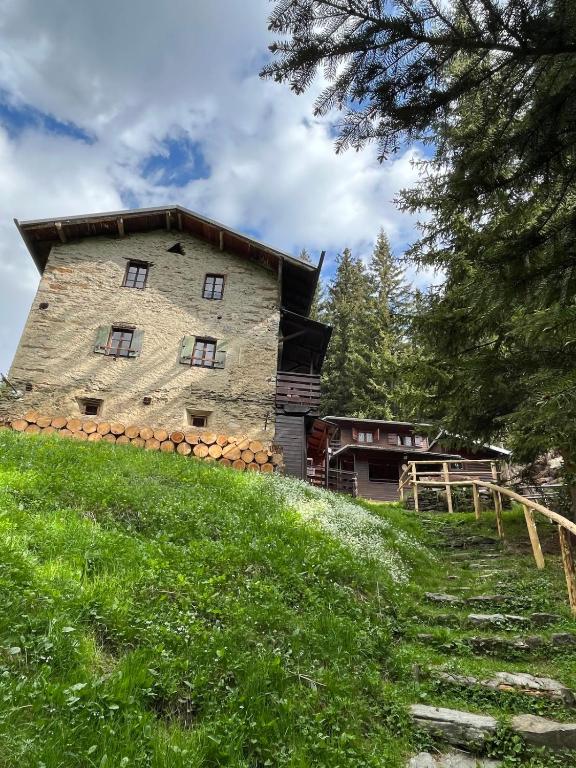a large stone building on top of a hill at Baita Pòz in Valfurva