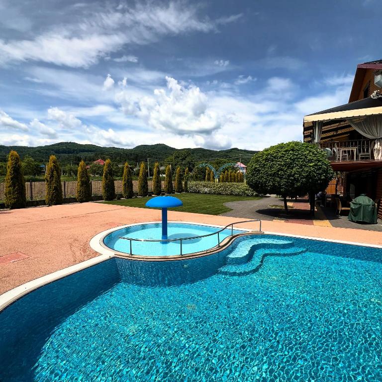 a swimming pool in a yard with a blue poolvisor at GorodOk in Migovo