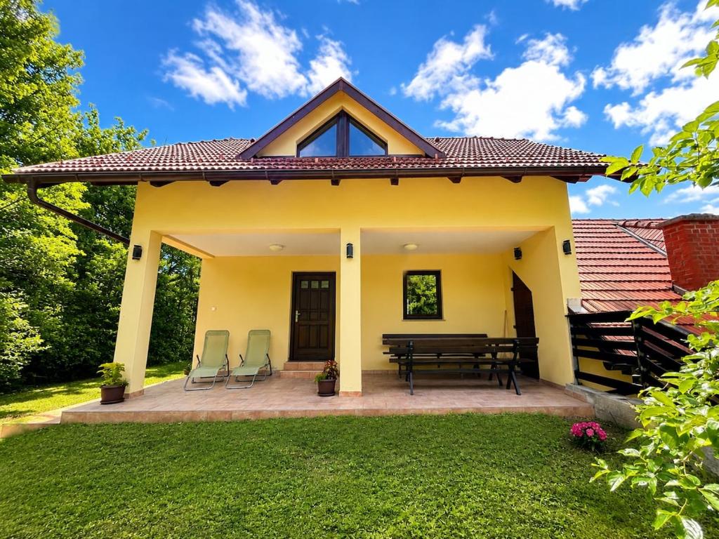 a small yellow house with a picnic table and chairs at Digital Detox House Haloze in Podlehnik