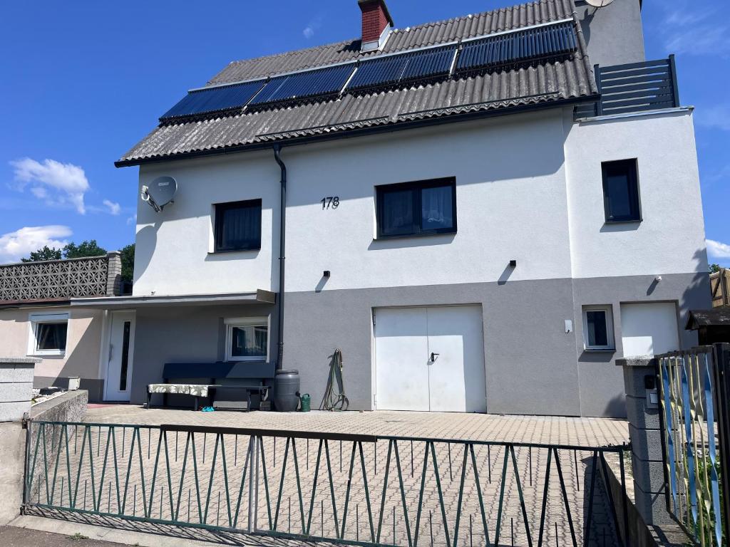 a white house with solar panels on its roof at Unterkunft LUSCHIN in Spielberg