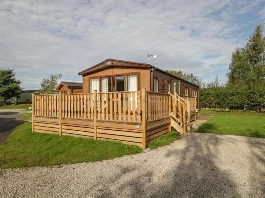 a cabin with a wooden fence and a house at 2-Bed Cabin - Sleeps 5 - Parking - Pet Friendly in Carnforth
