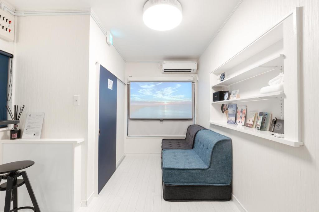 a living room with a blue chair and a window at 一軒家貸切 THREE FIELD Kobe Nakayamate in Kobe
