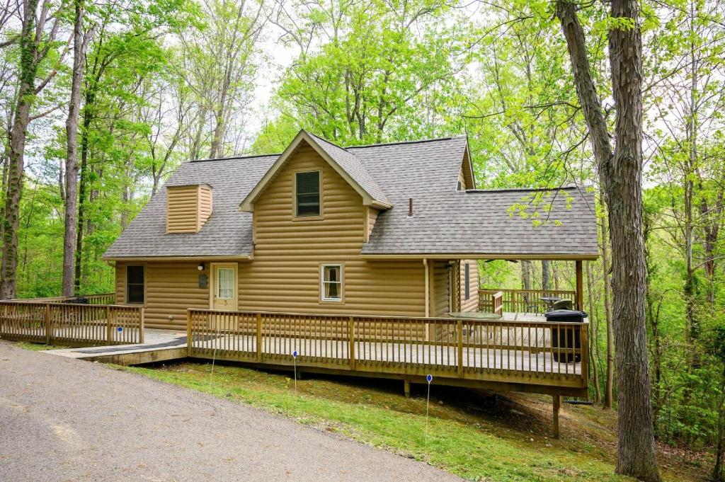 a large wooden house with a porch in the woods at Tree-Top Chalet in Logan
