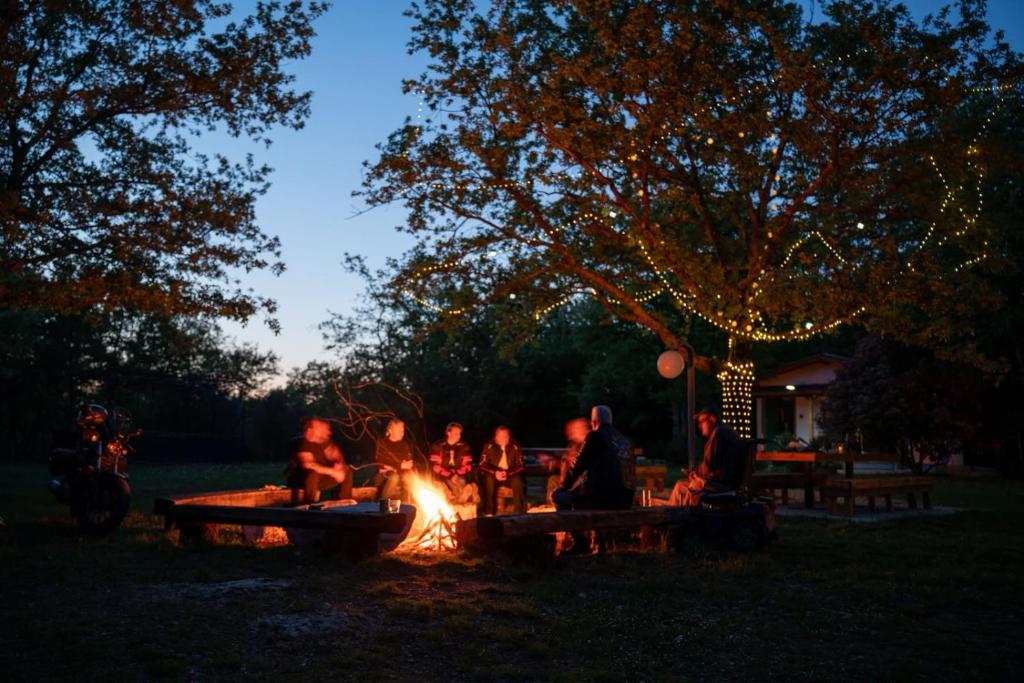 a group of people sitting around a fire in a park at Bikers camp in Poreč