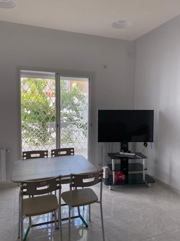 a dining room with a table and chairs and a television at Chez Brahim in Ariana