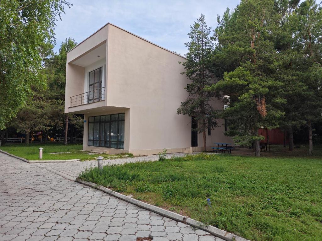 a large white house with a walkway in front of it at Вилла Витязь in Chok-Tal