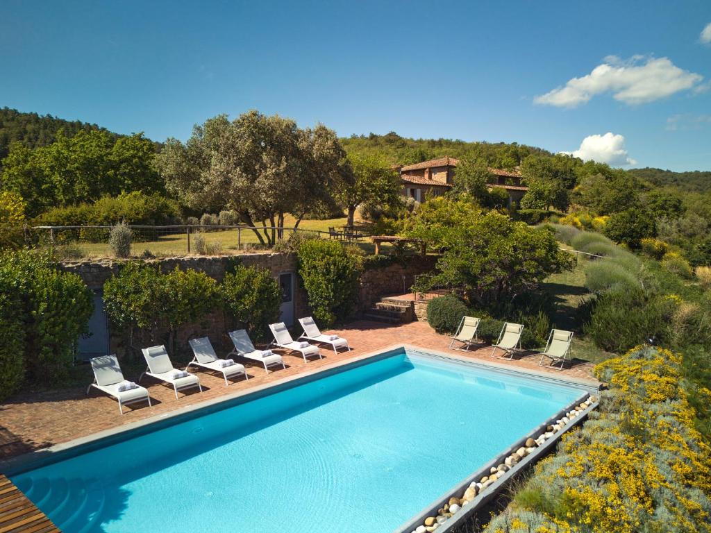 a swimming pool with lounge chairs and a house at La Locanda Volpaia in Radda in Chianti