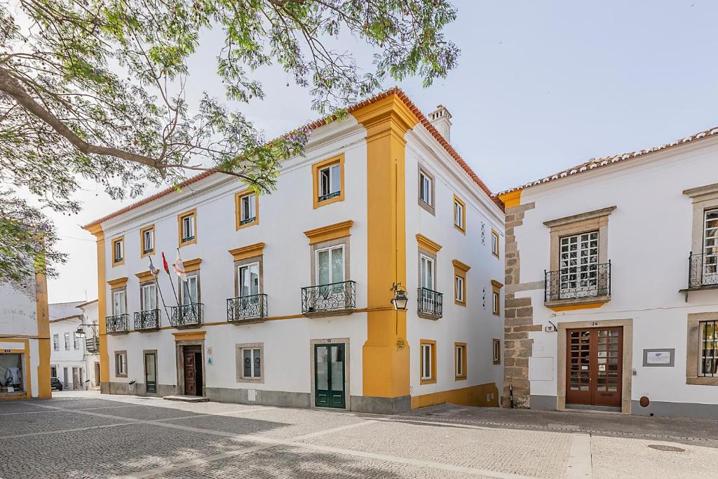a yellow and white building with a balcony at HI Évora – Pousada de Juventude in Évora