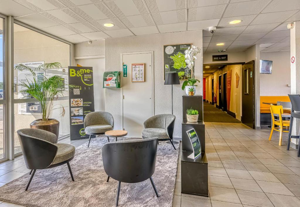 a waiting area with chairs and tables in a lobby at B&B HOTEL Bordeaux Sud Mios 3 étoiles in Mios