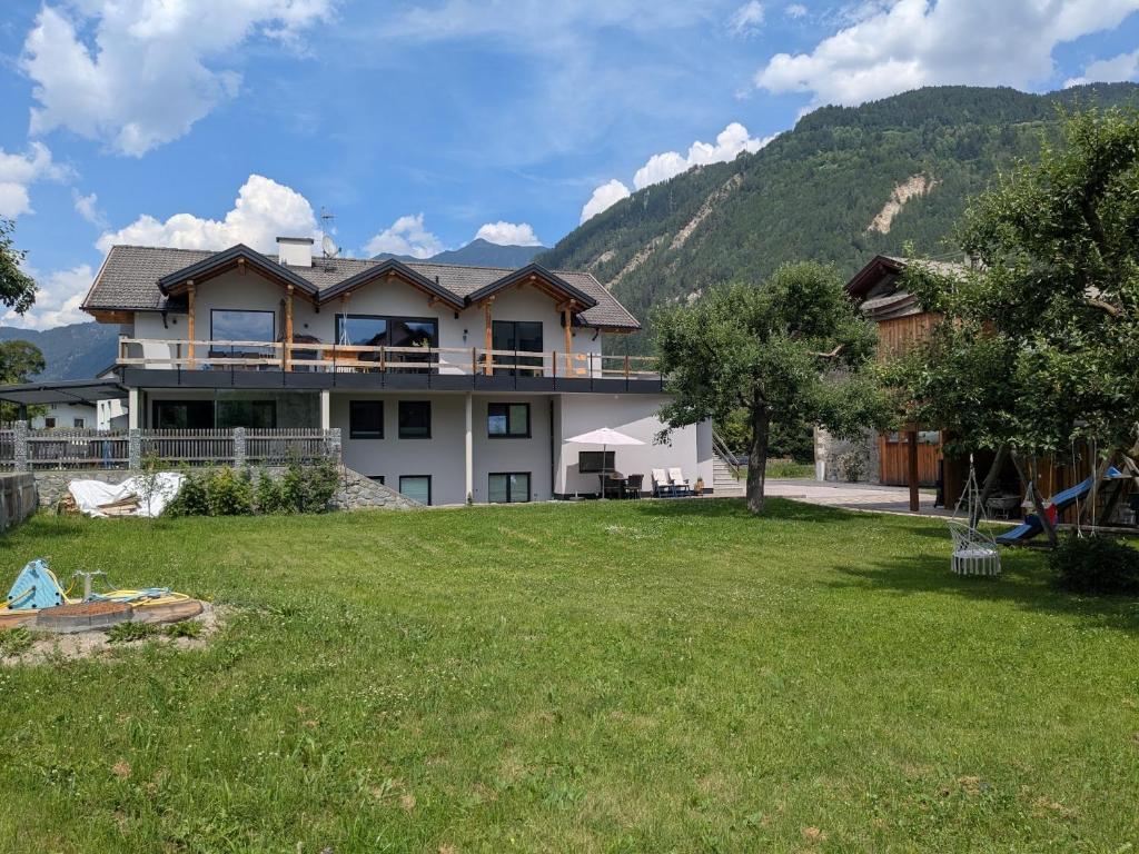 a large house with a large yard in front of a mountain at Appart Gfall in Ried im Oberinntal