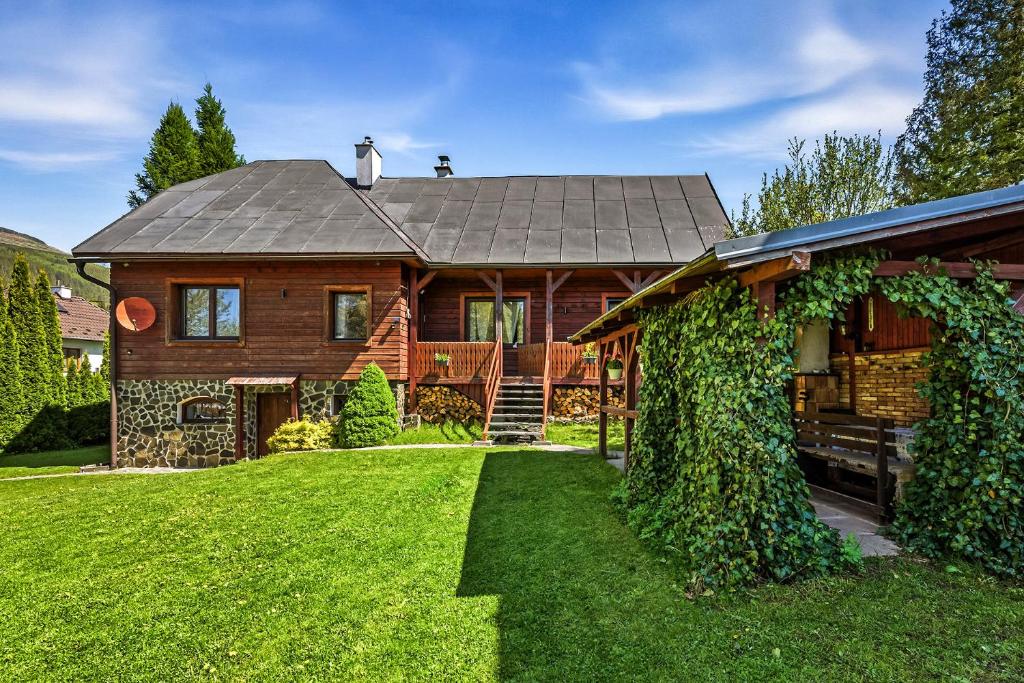 a large wooden house with a yard at Chlúpka u Luisa in Telgárt