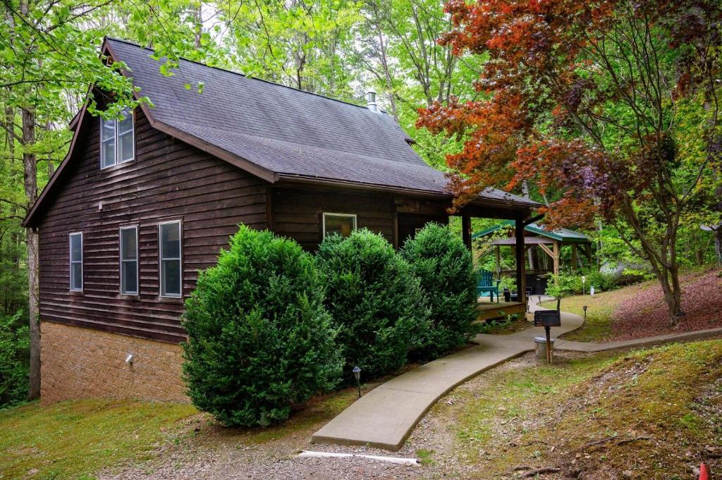 a small house with a porch and some bushes at Hemlock Hideaway in South Bloomingville
