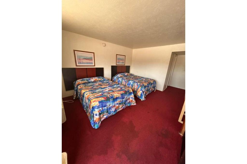 a hotel room with two beds and a red carpet at Desert Sands Denton near UNT I 35 TX in Denton