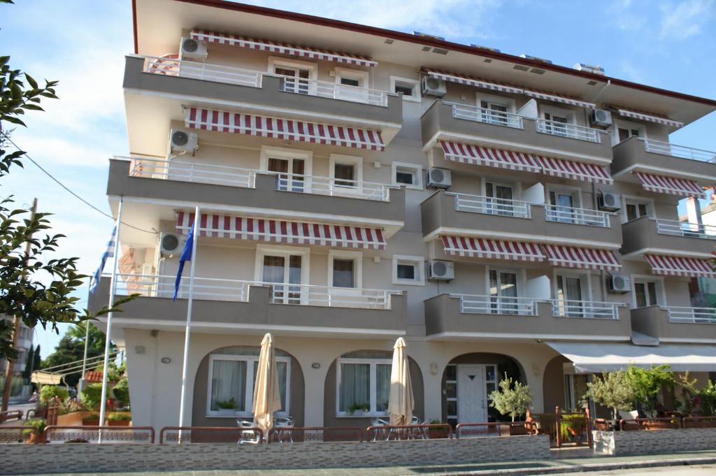 a large building with umbrellas in front of it at Iris by Dias in Olympic Beach