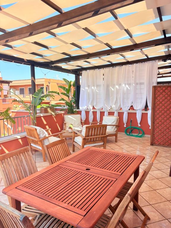 a wooden table and chairs on a patio at Villaelena Salento Mare in Marittima