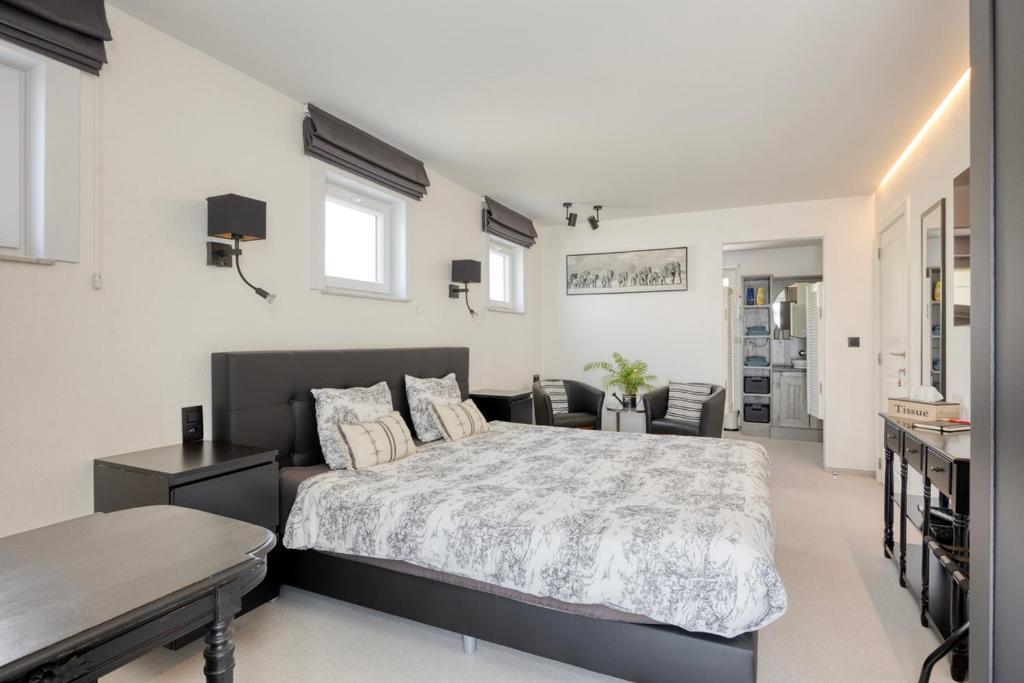 a bedroom with a bed and a living room at B&B Cosiness in Balen